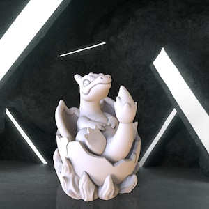 May include: A white ceramic figurine of a dragon hatching from an egg. The dragon is curled up inside the egg with its head and tail sticking out. The egg is cracked open and has a rough, textured surface.