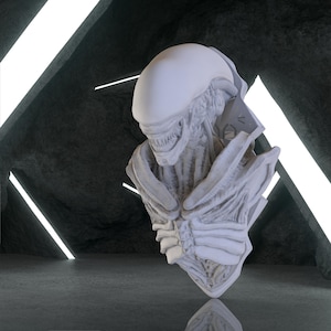May include: A detailed, off-white bust of an Alien creature, featuring a smooth, elongated head and intricate, textured details on the face and chest. The sculpture is set against a dark, textured background with bright, linear lighting, creating a dramatic effect.