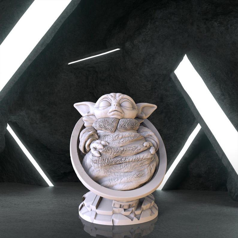 May include: A white ceramic figurine of a character from the Star Wars franchise, known as "The Child" or "Baby Yoda", sitting in a chair. The figurine is detailed with a furry robe and a peaceful expression.