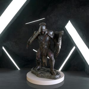 May include: A dark metallic figurine of a warrior wearing a full helmet and plate armor, holding a sword in the right hand and a shield in the left. The figure stands on a textured rocky base, featuring a weathered finish with visible scratches.