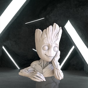 Puede incluir: Un busto blanco impreso en 3D de Groot de Guardianes de la Galaxia. La figura tiene una textura de árbol, con una cara sonriente y los brazos apoyados en la mejilla. El fondo es un espacio oscuro y futurista con luces de neón blancas.