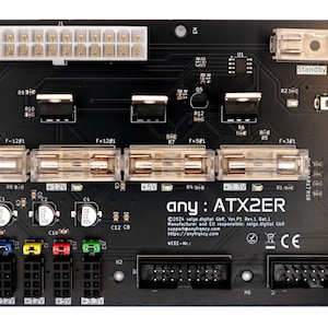 May include: A black circuit board with the text "any: ATX2ER" and the text "©2024 selge digital GR Ver.P1 Rev.1 Ba1.1" printed on it. The board has several connectors, including a 24-pin connector, a 4-pin connector, and a USB connector.