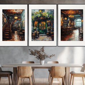 Könnte beinhalten: Drei gerahmte Gemälde, die das Innere eines Pariser Cafés zeigen. Die Gemälde sind im rustikalen Stil gehalten mit warmer Beleuchtung und einer gemütlichen Atmosphäre. Das Café ist mit Tischen und Stühlen gefüllt, und es sitzen Menschen und unterhalten sich. Die Gemälde hängen an einer Wand in einem Esszimmer mit einem Holztisch und Stühlen.