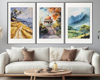 May include: Three framed watercolor paintings depicting different scenes. The first painting shows a path through a field of golden grass with a small village in the background. The second painting shows a white gazebo with a staircase leading up to it, surrounded by lush green trees. The third painting shows a mountain range with a blue sky and green trees in the foreground.