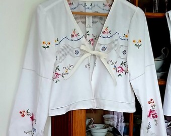 Blusa mediana de lino bordada con lazada frontal, parte superior de mantel reciclado.