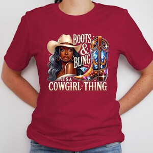 K&ouml;nnte beinhalten: Burgunderfarbenes T-Shirt mit einer Grafik einer Frau mit Cowboyhut, einem verzierten Cowboy-Stiefel und dem Text "Boots & Bling, It's a Cowgirl Thing". Das Design beinhaltet Diamanten und einen gold-braunen Stiefel.