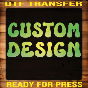 May include: A DTF transfer design with the words "CUSTOM DESIGN" in a retro font, shaded from green to yellow. The text "READY FOR PRESS" is at the bottom, all on a black background with a wood grain border.