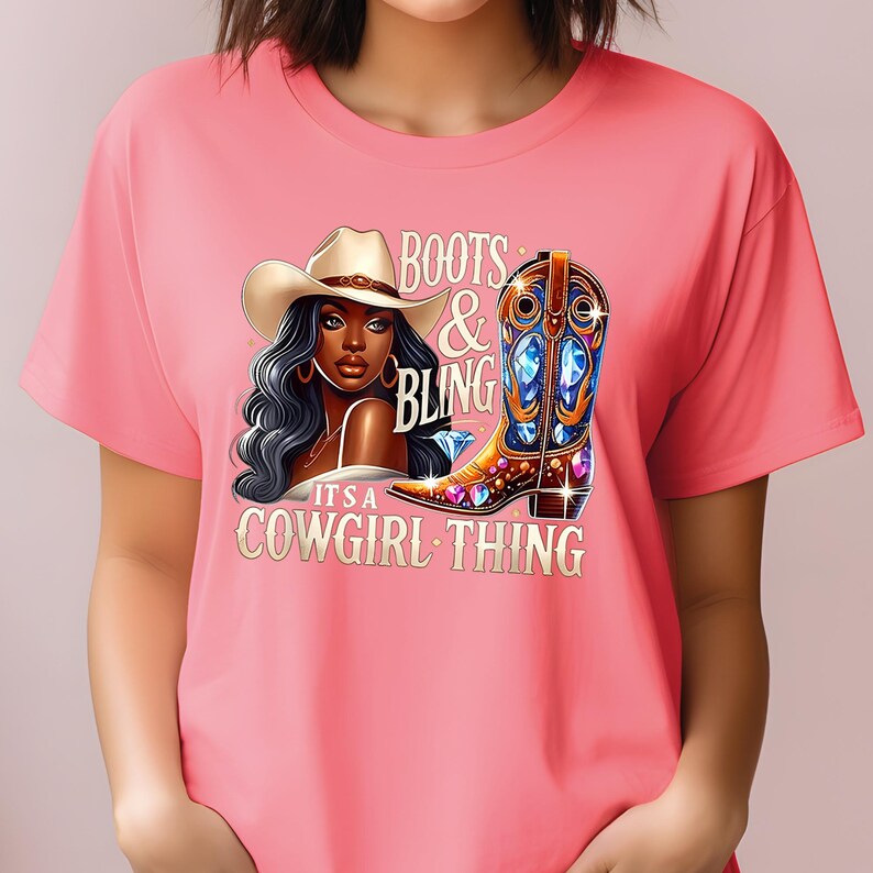 K&ouml;nnte beinhalten: Rosafarbenes T-Shirt mit einer Grafik einer Frau mit Cowboyhut und einem mit Juwelen besetzten Cowboy-Stiefel. Der Text auf dem Shirt lautet "Boots & Bling, It's a Cowgirl Thing."