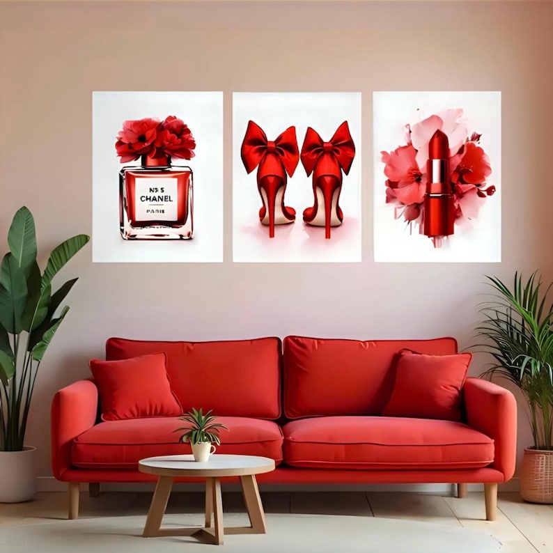 May include: Three framed art prints featuring a perfume bottle, high heels, and lipstick in shades of red. The perfume bottle is labeled "N&deg;5 CHANEL PARIS". The high heels have large red bows. The lipstick is surrounded by red flowers.