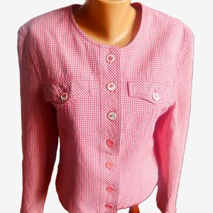May include: A pink and white gingham blazer with a round neckline and long sleeves. The blazer has two front pockets and is buttoned down the front with pink buttons. The garment is displayed on a mannequin.