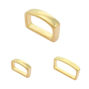 May include: Three gold-coloured rectangular metal rings. The rings have rounded edges and a smooth, shiny finish. The sizes of the rings vary, with one larger ring at the top and two smaller rings below.