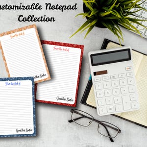 Puede incluir: Una colección de blocs de notas personalizables con páginas rayadas y bordes decorativos en patrones de corcho, rojo y azul. Los blocs de notas presentan el texto "From the desk of" y un nombre. También se ve una calculadora blanca, gafas y una agenda.