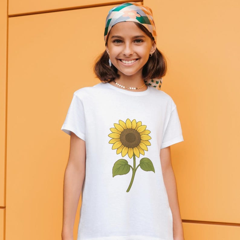 Smiling girl wearing a white T-shirt featuring a cheerful sunflower illustration in Studio Ghibli-inspired style. Perfect mockup to showcase how floral SVG designs look on kids' clothing for fun and creative apparel.