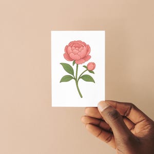 Hand holding a minimalist floral sticker card featuring a soft pink peony with green leaves. Studio Ghibli-inspired design ideal for showcasing printable SVG/PNG flower art in a clean and elegant presentation.