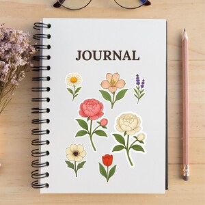 Aesthetic flat lay of a spiral journal decorated with Studio Ghibli-style flower stickers including tulip, peony, daisy, and lavender. Ideal for showcasing how floral SVG/PNG designs can be used for journaling and planner decoration.