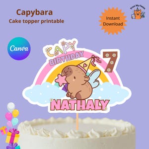 May include: A printable cake topper with a cartoon capybara wearing a party hat, holding a star wand, and set against a rainbow and cloud background. The topper reads "Happy Birthday Nathaly" and includes the number "7".