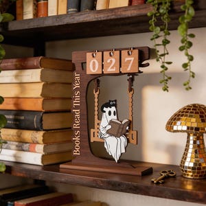 Letrero de madera con el mensaje "Lectura fantasmal" y decoración de libros leídos este año.