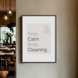 Puede incluir: Impresión enmarcada con el texto "Keep Calm Keep Cleaning" en gris, acompañada de un diseño minimalista en forma de corazón. La impresión tiene un fondo claro y un marco gris oscuro, adecuada para la decoración del hogar.