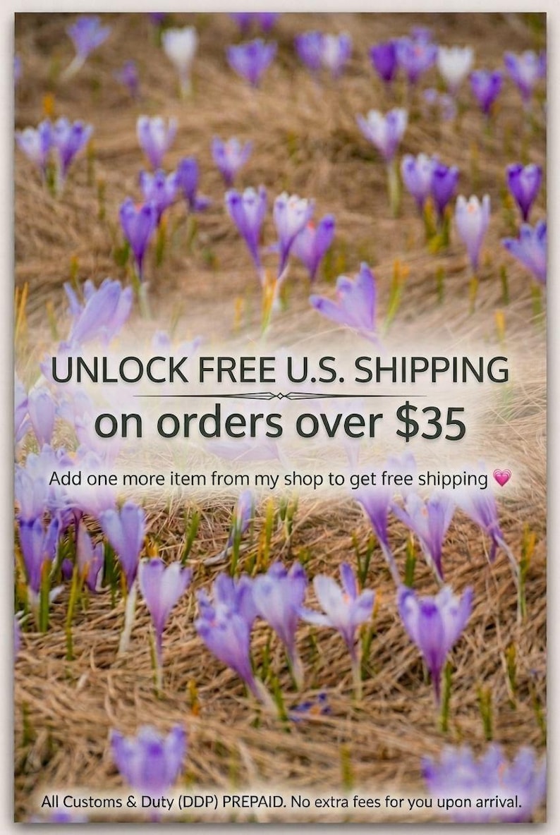 May include: A field of purple and white crocus flowers blooming in dry, brown grass. The image features a soft focus effect on the flowers, with the petals displaying various shades of violet, lavender, and white against the textured ground.