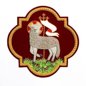 May include: Embroidered patch featuring a lamb with a halo, holding a banner with a cross, set against a burgundy background. The lamb is covered in silver beads, with gold and green accents. The patch has a gold border.
