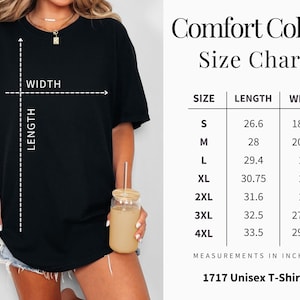 May include: Black t-shirt with a size chart for Comfort Colors 1717 Unisex T-shirts. The chart shows measurements in inches for sizes S to 4XL. The shirt's length and width are indicated with dashed lines. The model is wearing the black t-shirt.