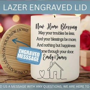 Puede incluir: Una vela blanca con una escritura negra que dice "New Home Blessing" y una ilustraci&oacute;n de una casa. Una tapa de madera con el texto "Felicitaciones por tu nuevo hogar" est&aacute; al lado de la vela. Las palabras "Lazer Engraved Lid" est&aacute;n en la parte superior.