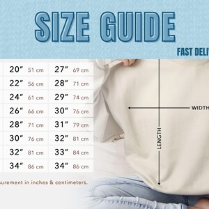 May include: A size guide chart with measurements in inches and centimeters for a sweatshirt. The chart includes sizes S to 5XL, with corresponding width and length measurements. The text "SIZE GUIDE" is at the top.