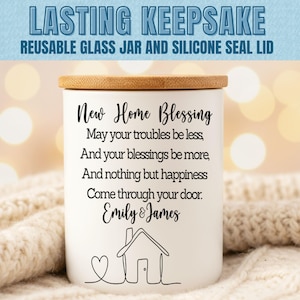 Puede incluir: Un tarro de cer&aacute;mica blanco con tapa de bamb&uacute;, con la inscripci&oacute;n "New Home Blessing" y una ilustraci&oacute;n de una casa. El tarro est&aacute; dise&ntilde;ado para recuerdos y tiene las palabras "Lasting Keepsake" en la parte superior.