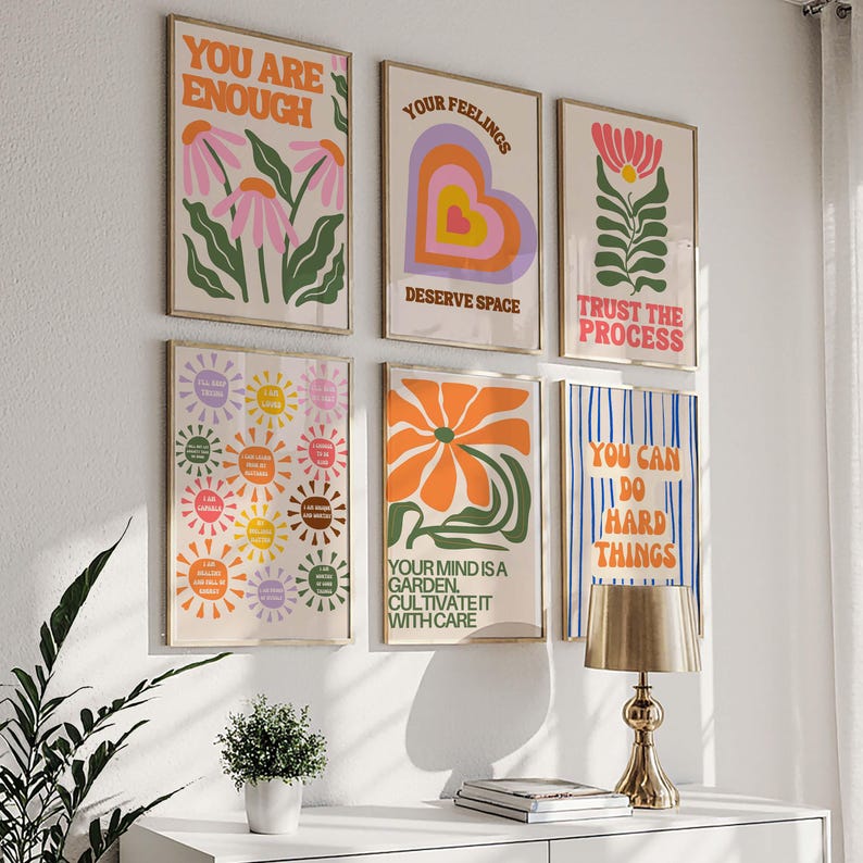 May include: A collection of six framed art prints with motivational quotes and floral designs. The prints feature phrases like "You Are Enough" and "Trust the Process" in a retro color palette of orange, pink, and green.