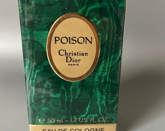 Könnte beinhalten: Eine rechteckige Parfümbox mit grünem Marmormuster. Die Box zeigt ein goldenes Oval mit dem Wort "POISON" über "Christian Dior PARIS". Auf der Box steht "e 50 ml - 1.7 US. FL. OZ." und "EAU DE COLOGNE VAPORISATEUR".