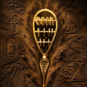 Könnte beinhalten: Ein goldfarbener Anhänger in Form eines Abakus mit einem Kobra-Kopf-Design, vor einem strukturierten braunen Hintergrund mit ägyptischen Hieroglyphen. Der Anhänger hat kreisförmige Perlen und horizontale Stäbe. Der Hintergrund enthält Schnitzereien eines Auges, eines Skarabäus und anderer Symbole.