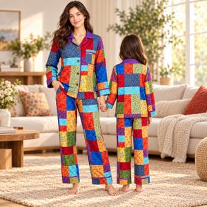 May include: Two sets of matching pajamas featuring a vibrant, multi-colored patchwork design with various floral and geometric patterns in shades of red, blue, yellow, green, and purple, including long-sleeved button-down tops and long pants.