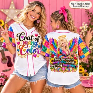 May include: A white baseball jersey featuring a colorful patchwork pattern on the sleeves. The front displays the text "Coat of many Color" with hearts. The back features a graphic of a woman with wings and a guitar, with the text "I now have many colors to match my coat of many colors."