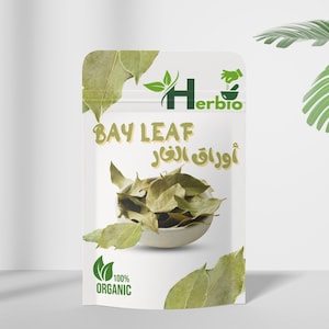 Puede incluir: Una bolsa blanca de hojas de laurel con el texto "BAY LEAF" y texto árabe. La bolsa presenta un logotipo verde y las palabras "100% ORGANIC". Las hojas de laurel son de color verde claro.