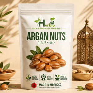 Può includere: Una busta bianca verticale di noci di argan Herbio con logo verde, testo in inglese e arabo e un'illustrazione di noci marroni con foglie verdi. L'etichetta include icone per 100% naturale, alta qualità e prodotto puro e autentico.