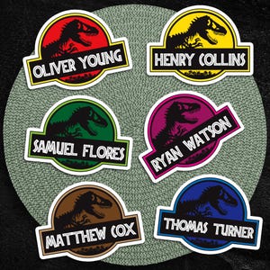 May include: Six colorful stickers featuring a dinosaur silhouette within a circular design. Each sticker has a different color scheme and a name printed on a rectangular label. Names include Oliver Young, Henry Collins, Samuel Flores, Ryan Watson, Matthew Cox, and Thomas Turner.