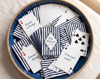 May include: A deck of playing cards with a navy blue and white vertical stripe pattern, housed in a blue ceramic bowl. The cards feature custom text including "Forever & Always," "The Mason EST. 2020," and "To the best couple!" alongside standard card suits.