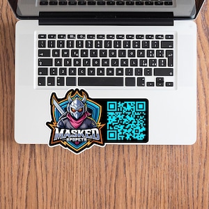 May include: A sticker featuring a masked character with a sword, set against a blue shield. The text "MASKED SPOPETS" is below the character. A QR code is on the right side of the sticker. The sticker is on a laptop.