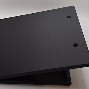 May include: A black metal shelf bracket with two holes for mounting. The bracket is angled for support.