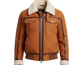 May include: A brown suede jacket with a cream-colored shearling collar and cuffs. The jacket features two front pockets, a zip-up closure, and brown leather trim. The jacket has a ribbed hem and cuffs.