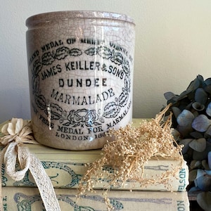 Peut inclure: Un pot à marmelade cylindrique en céramique avec une finition émaillée craquelée beige clair. L'avant présente un texte imprimé noir indiquant James Keiller & Sons Dundee Marmalade, ainsi que des médailles de Vienne et de Londres en 1862.