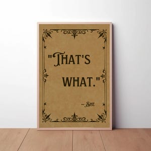 Puede incluir: Impresión enmarcada con la cita "That's What." en texto negro sobre un fondo beige. La impresión tiene adornos negros decorativos en los bordes y la palabra "- She" debajo. El marco es de color rosa claro.