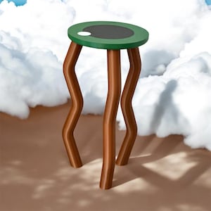 Puede incluir: Una mesa redonda verde y negra con un punto blanco en la parte superior. La mesa tiene cuatro patas marrones y onduladas.