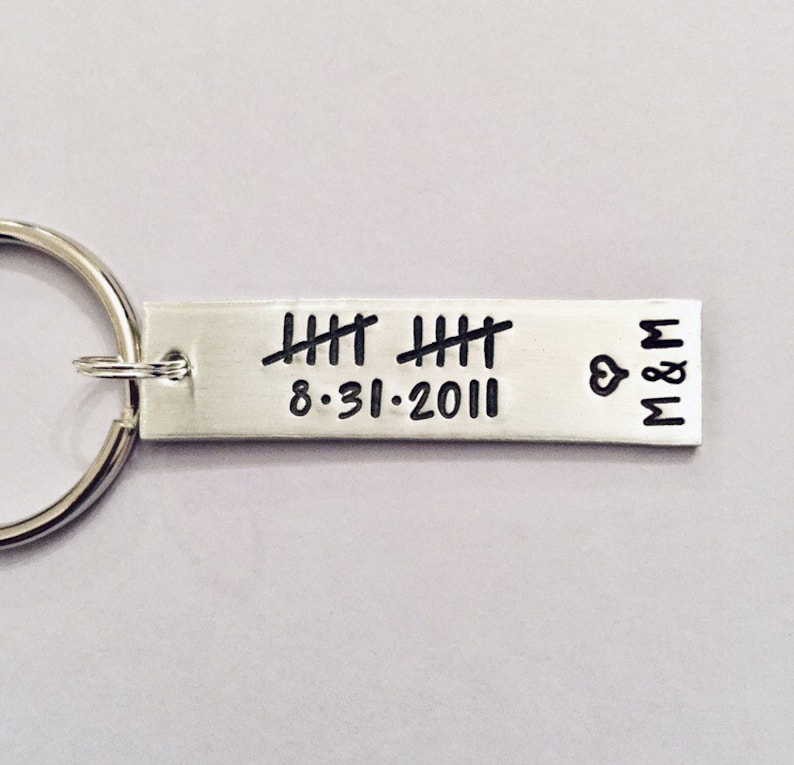 May include: Silver keychain with a date, "8-31-2011", and tally marks. The keychain also has a heart and the initials "M&M".