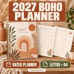 May include: A 2027 spiral-bound planner with a cover featuring a tan, brown, and green abstract landscape design with a sun and rainbow. Two interior pages are visible, showing a January 2027 monthly calendar and a weekly plan layout.