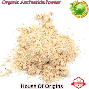 May include: A close-up of a pile of light brown organic asafoetida powder. The powder is 100% natural and is labeled "House of Origins".