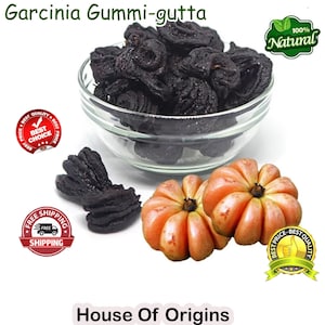 Puede incluir: Un bol de fruta Garcinia Gummi-gutta seca, también conocida como tamarindo de Malabar, con dos frutas enteras al lado. El bol está sobre un fondo blanco con texto que dice "Garcinia Gummi-gutta", "House of Origins", "100% Natural", "Mejor precio - Mejor calidad", y "Envío gratuito".
