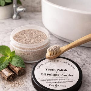 Peut inclure: Un pot de poudre à polir les dents et de bain de bouche à l'huile avec une brosse à dents en bois. L'étiquette indique "Interconnected Herbalism Tooth Polish + Oil Pulling Powder". Ingrédients : silice amorphe naturelle, poudre d'écorce de neem.