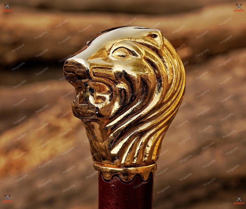 May include: A gold lion head finial with detailed carvings. The finial is mounted on a red wooden base.