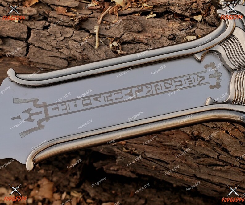 May include: A close-up of a silver-colored sword blade with etched symbols and a decorative handle. The blade has a polished finish and is set against a textured wooden background. The sword's design suggests a fantasy or historical theme.